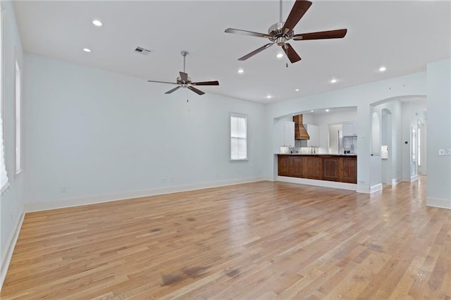 unfurnished living room with ceiling fan and light wood-type flooring