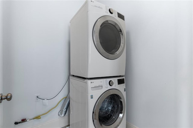 clothes washing area featuring stacked washer and dryer