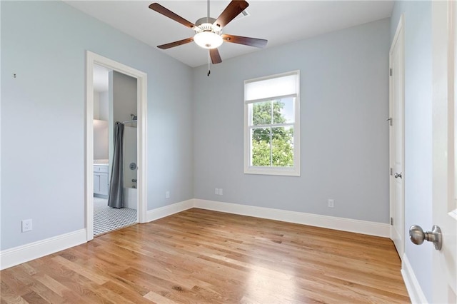 unfurnished bedroom featuring ceiling fan, light hardwood / wood-style floors, and a walk in closet