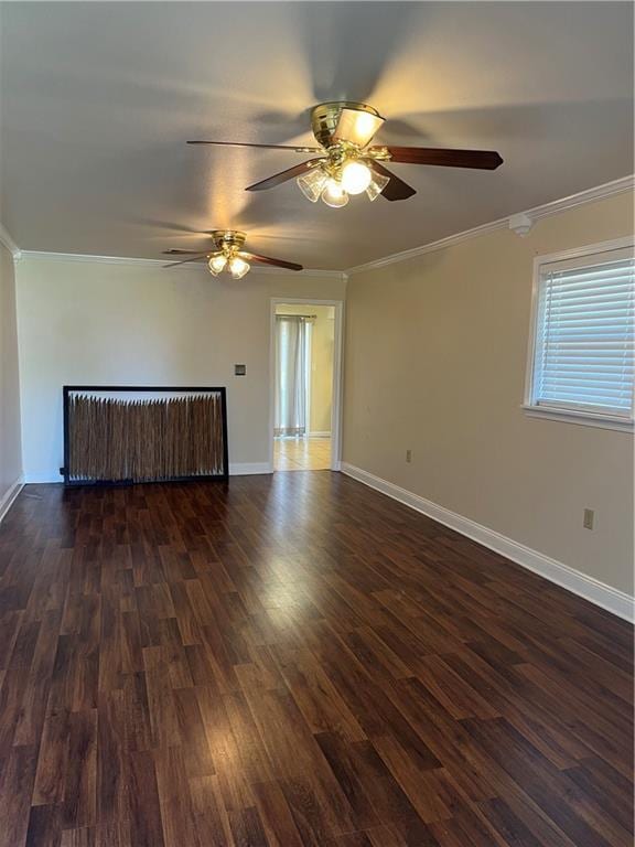 spare room featuring ornamental molding, radiator heating unit, dark wood finished floors, and baseboards