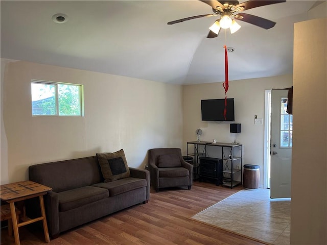 living area with a ceiling fan, vaulted ceiling, and wood finished floors