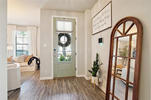 foyer featuring baseboards and wood finished floors