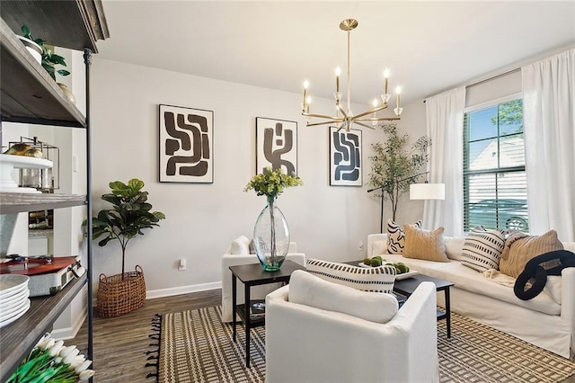 living room with baseboards, a notable chandelier, and wood finished floors