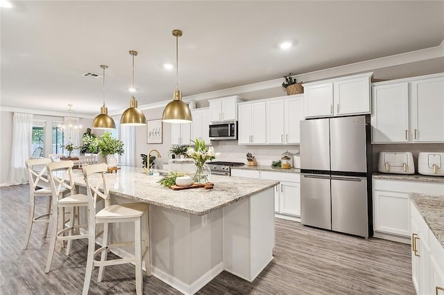 kitchen featuring stainless steel appliances, visible vents, decorative backsplash, and white cabinetry