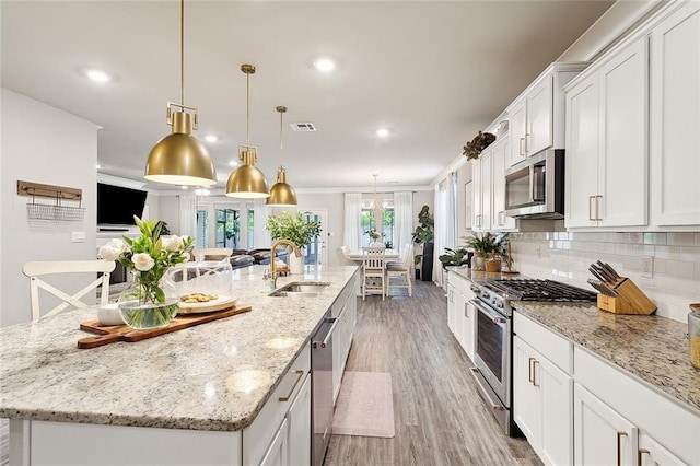 kitchen featuring tasteful backsplash, visible vents, appliances with stainless steel finishes, white cabinetry, and a sink