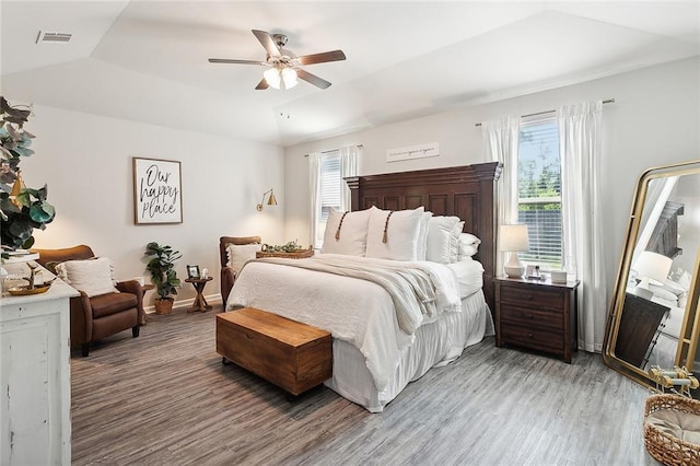 bedroom with baseboards, lofted ceiling, wood finished floors, and a ceiling fan