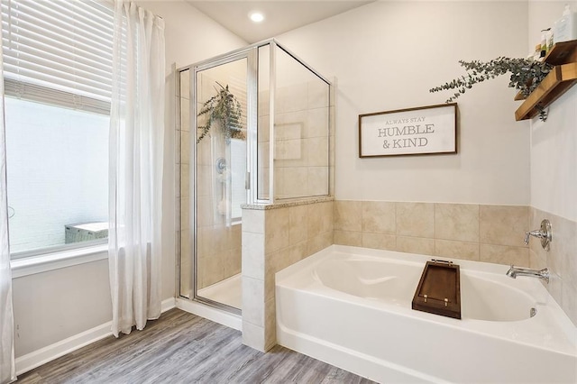 bathroom with wood-type flooring and independent shower and bath