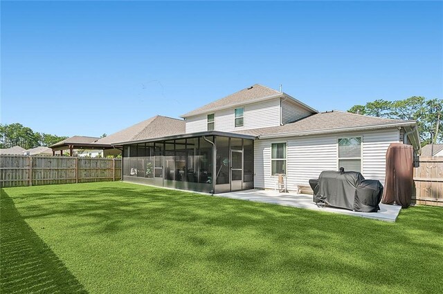 back of house with a lawn, a sunroom, and a patio