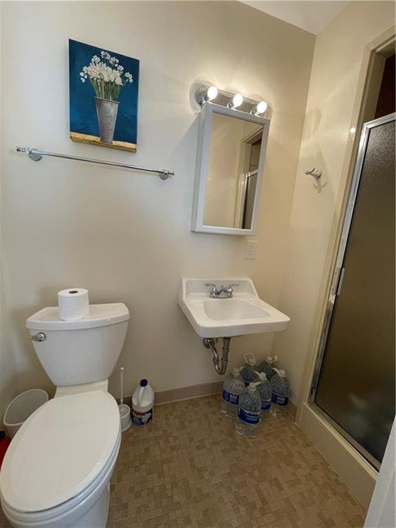 bathroom with an enclosed shower, toilet, and sink