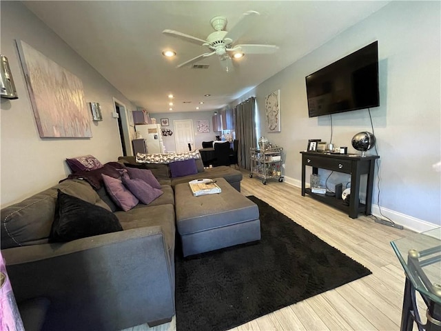 living room with ceiling fan and light hardwood / wood-style flooring