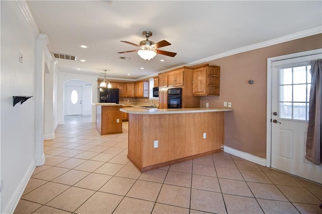 3000 Arlington St, Jefferson, LA 70121 - kitchen featuring black appliances, arched walkways, light countertops, a peninsula, and light tile patterned floors