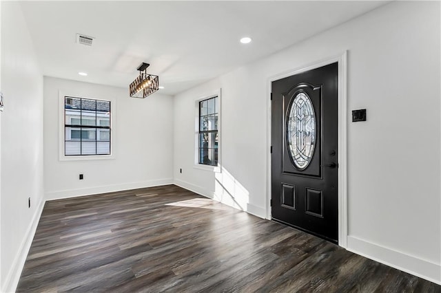 foyer entrance featuring dark hardwood / wood-style flooring and an inviting chandelier