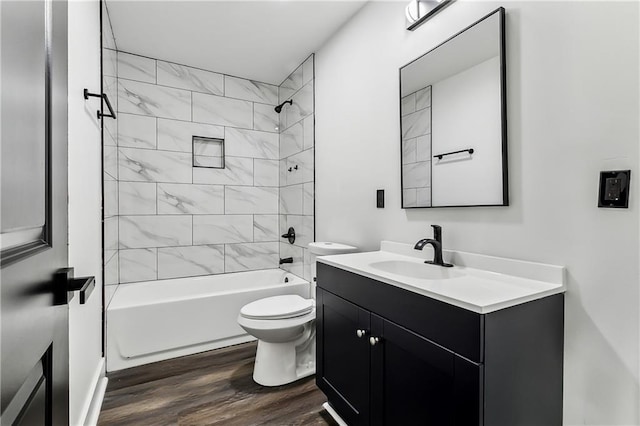 full bathroom with hardwood / wood-style flooring, vanity, toilet, and tiled shower / bath