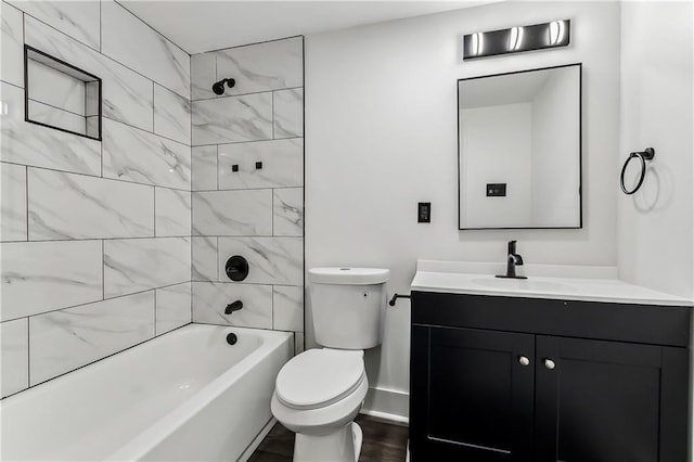 full bathroom featuring vanity, tiled shower / bath combo, hardwood / wood-style flooring, and toilet