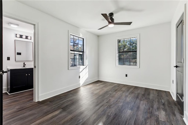 unfurnished bedroom with connected bathroom, dark hardwood / wood-style floors, ceiling fan, and sink