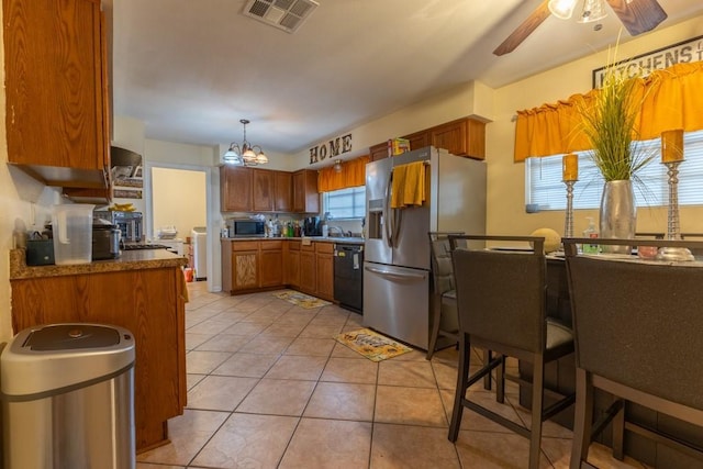 kitchen featuring light tile patterned floors, stainless steel appliances, ceiling fan with notable chandelier, and decorative light fixtures