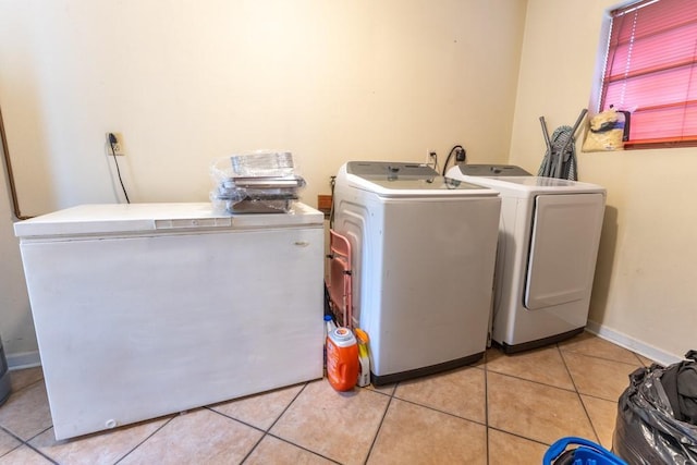 laundry room with light tile patterned floors and washing machine and clothes dryer