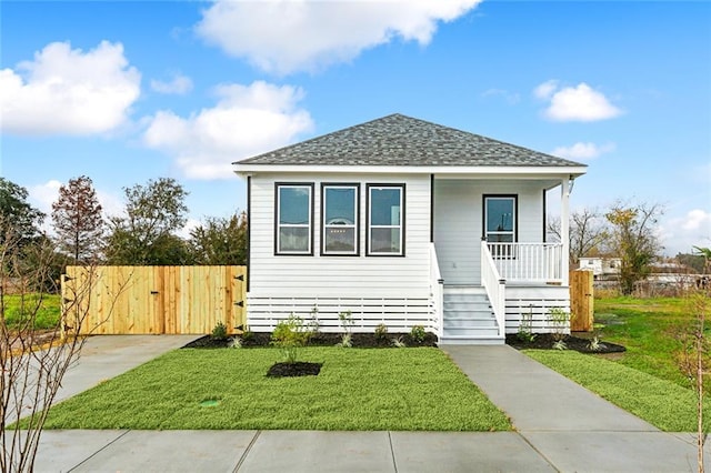 view of front of property with covered porch and a front lawn