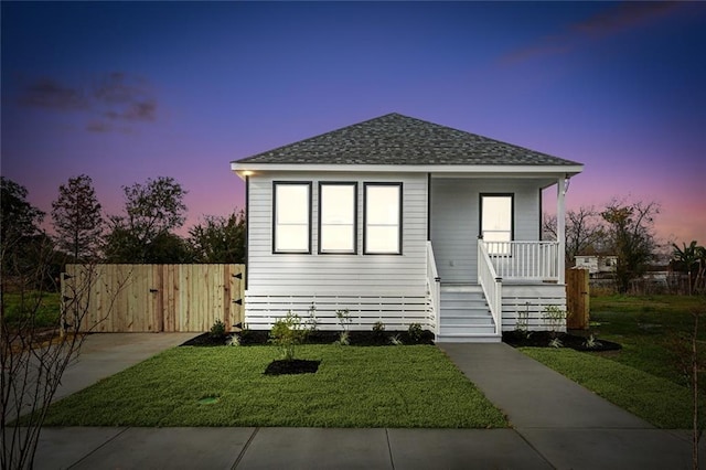 view of front of property with a porch and a yard