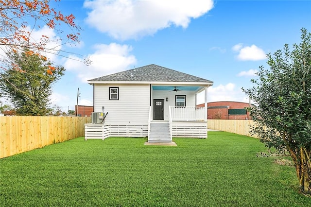 back of house with a lawn, ceiling fan, and covered porch