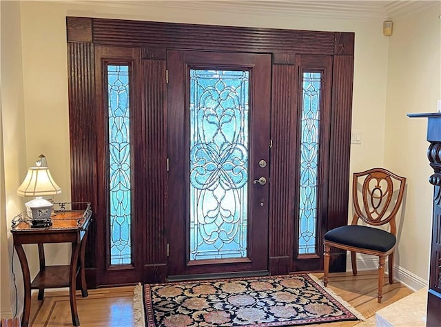 entryway featuring light wood-type flooring and ornamental molding