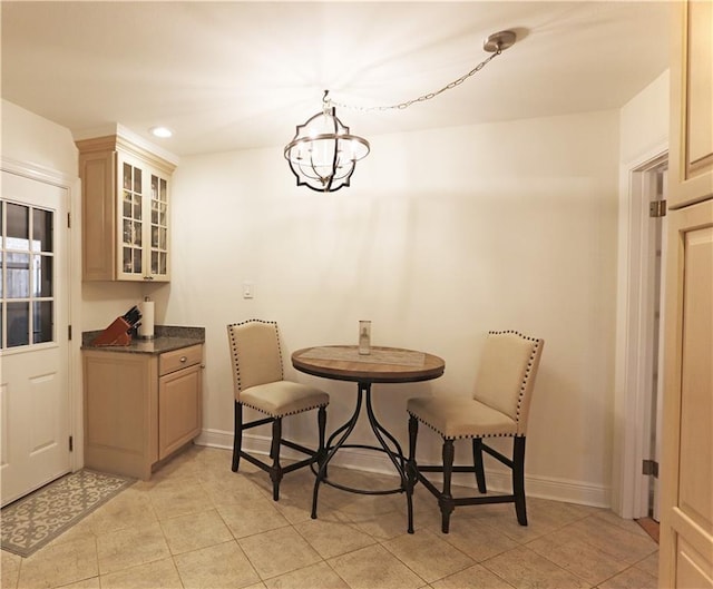 tiled dining room featuring an inviting chandelier