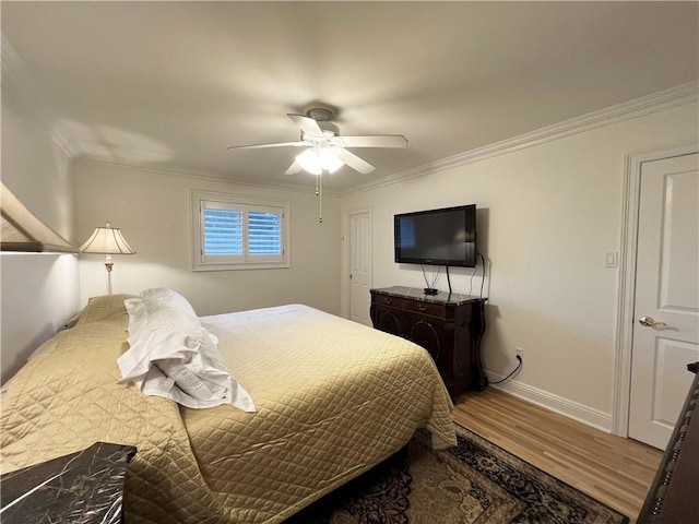 bedroom featuring ceiling fan, crown molding, and wood-type flooring