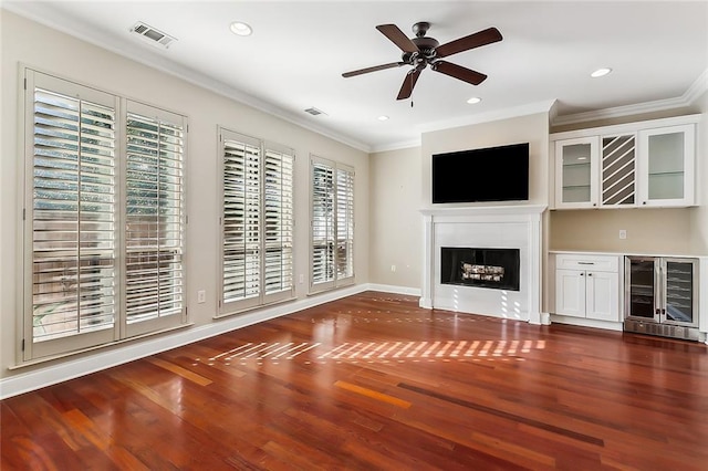 unfurnished living room with dark hardwood / wood-style floors, wine cooler, ceiling fan, and ornamental molding