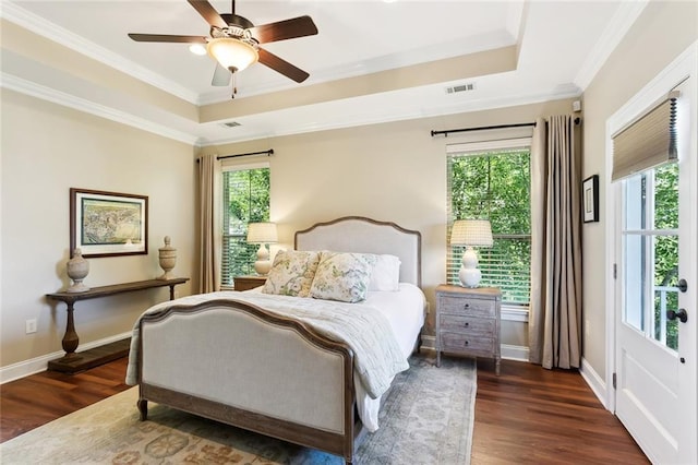 bedroom featuring dark hardwood / wood-style flooring, a tray ceiling, ceiling fan, and crown molding