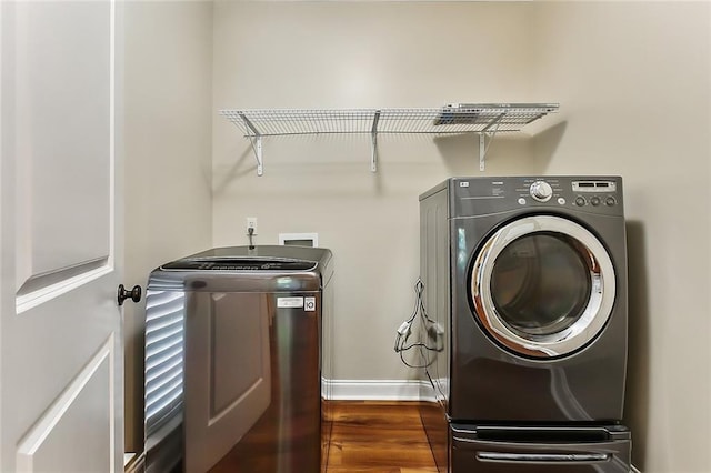 clothes washing area featuring washing machine and dryer and dark wood-type flooring