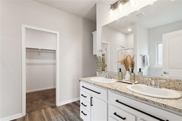 bathroom with wood-type flooring, a shower, and vanity