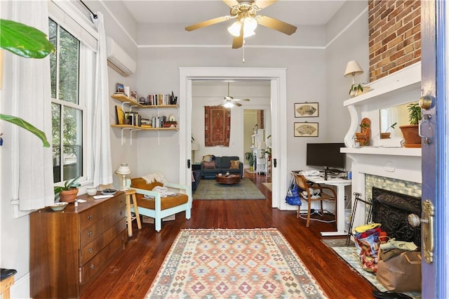 sitting room featuring a wall mounted AC, ceiling fan, dark hardwood / wood-style floors, and a brick fireplace