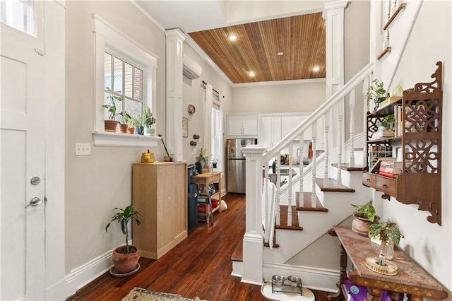 staircase featuring wood-type flooring, an AC wall unit, wooden ceiling, and crown molding