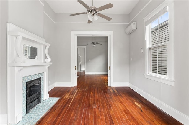 unfurnished living room featuring a tiled fireplace, ceiling fan, dark hardwood / wood-style flooring, and a wall mounted air conditioner