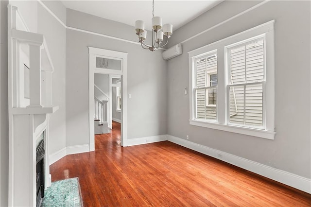 unfurnished dining area with a wall mounted AC, hardwood / wood-style flooring, and an inviting chandelier