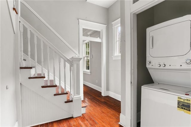 washroom with stacked washer and dryer and hardwood / wood-style floors