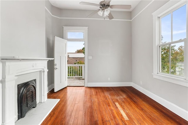 unfurnished living room with hardwood / wood-style floors, a wealth of natural light, and ceiling fan