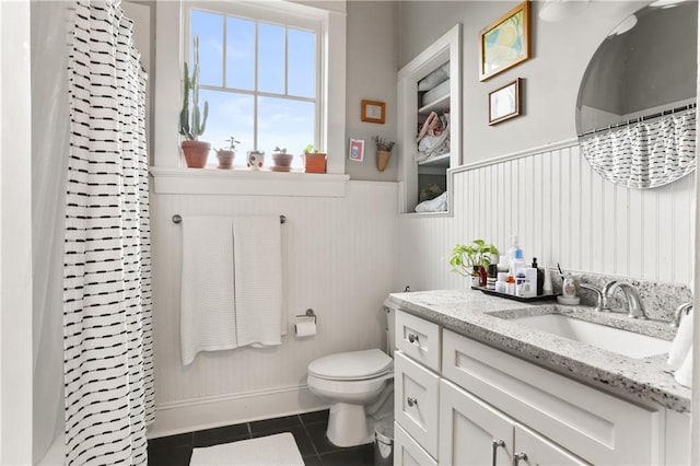 bathroom featuring tile patterned flooring, a shower with curtain, vanity, and toilet