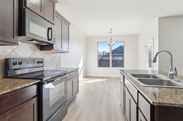 kitchen featuring dark brown cabinetry, stainless steel appliances, sink, pendant lighting, and a chandelier