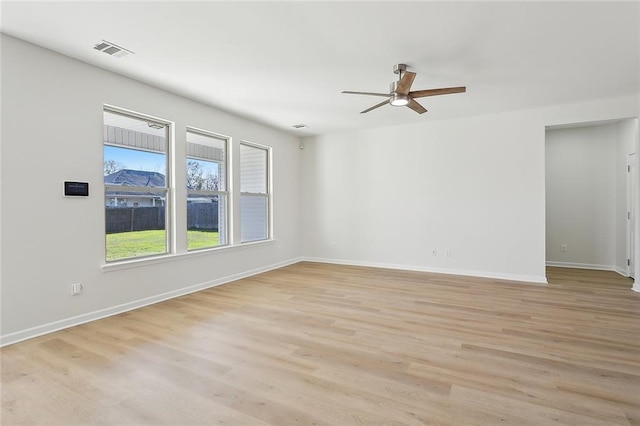 empty room with ceiling fan and light hardwood / wood-style flooring