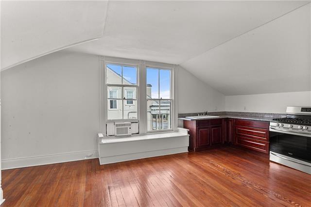bonus room with a sink, wood-type flooring, cooling unit, and lofted ceiling