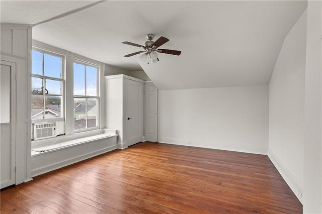 bonus room with baseboards, ceiling fan, cooling unit, wood finished floors, and vaulted ceiling