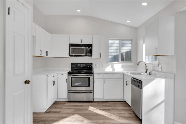 kitchen featuring sink, white cabinets, stainless steel appliances, and light hardwood / wood-style floors