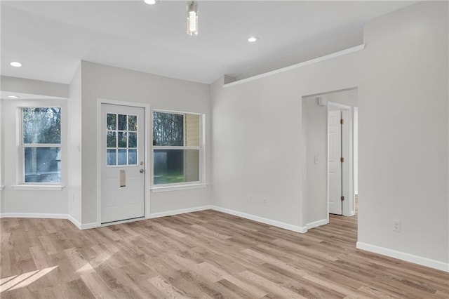 interior space with light hardwood / wood-style flooring, a healthy amount of sunlight, and lofted ceiling