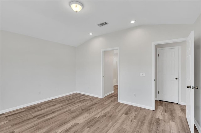 unfurnished bedroom with light wood-type flooring and lofted ceiling