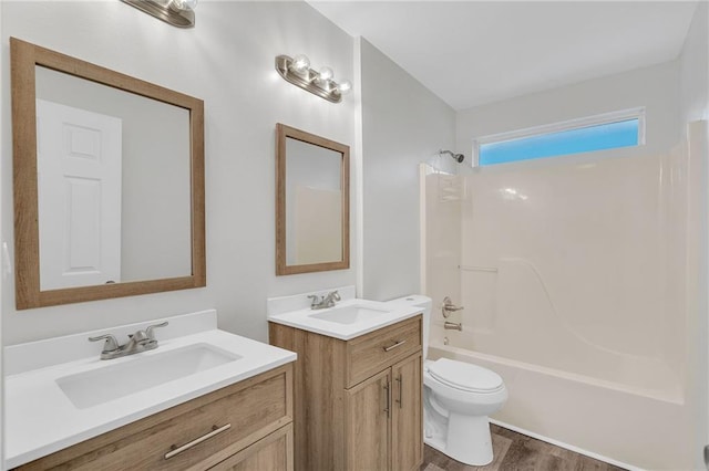 full bathroom featuring hardwood / wood-style flooring, vanity, toilet, and tub / shower combination