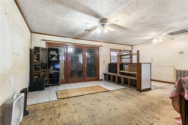 interior space with a textured ceiling, ceiling fan, and crown molding