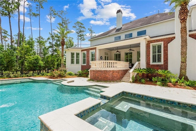 back of property with a pool with hot tub and ceiling fan