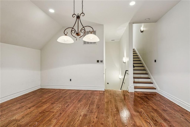 interior space with lofted ceiling, wood-type flooring, and an inviting chandelier