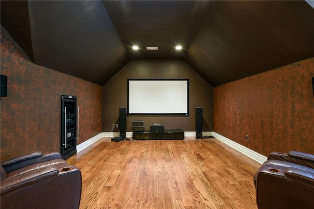 home theater with hardwood / wood-style floors and lofted ceiling